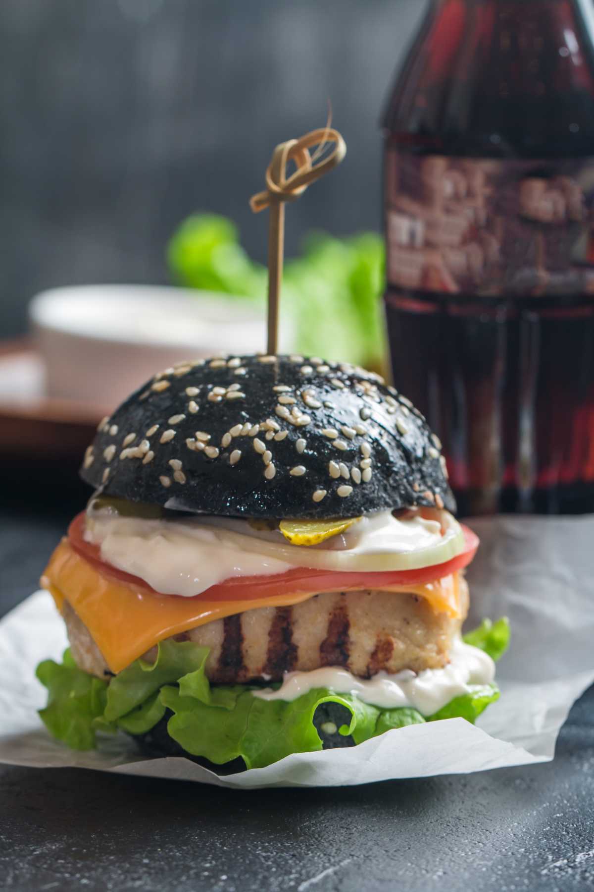 Ein Hamburger mit einem Brötchen, welches mit Aktifkohle gebacken und ganz schwarz ist.Das Bild ist ein Teil des Acala Blogbeitrages:  Aktivkohle, Anwendung und Hintergründe