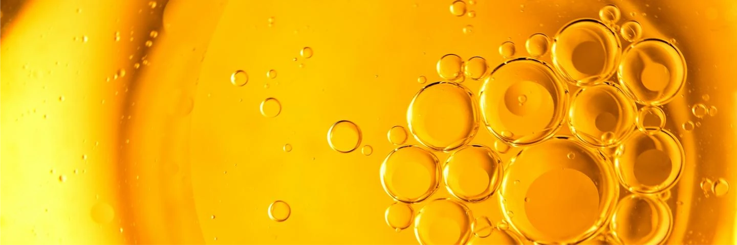Gelbes Öl in Nahaufnahme. Das bild ist en teil des Beitrags: Warum bildet Wasser eine Tropfenform, Öl aber nicht?Auf dem Acalblog.