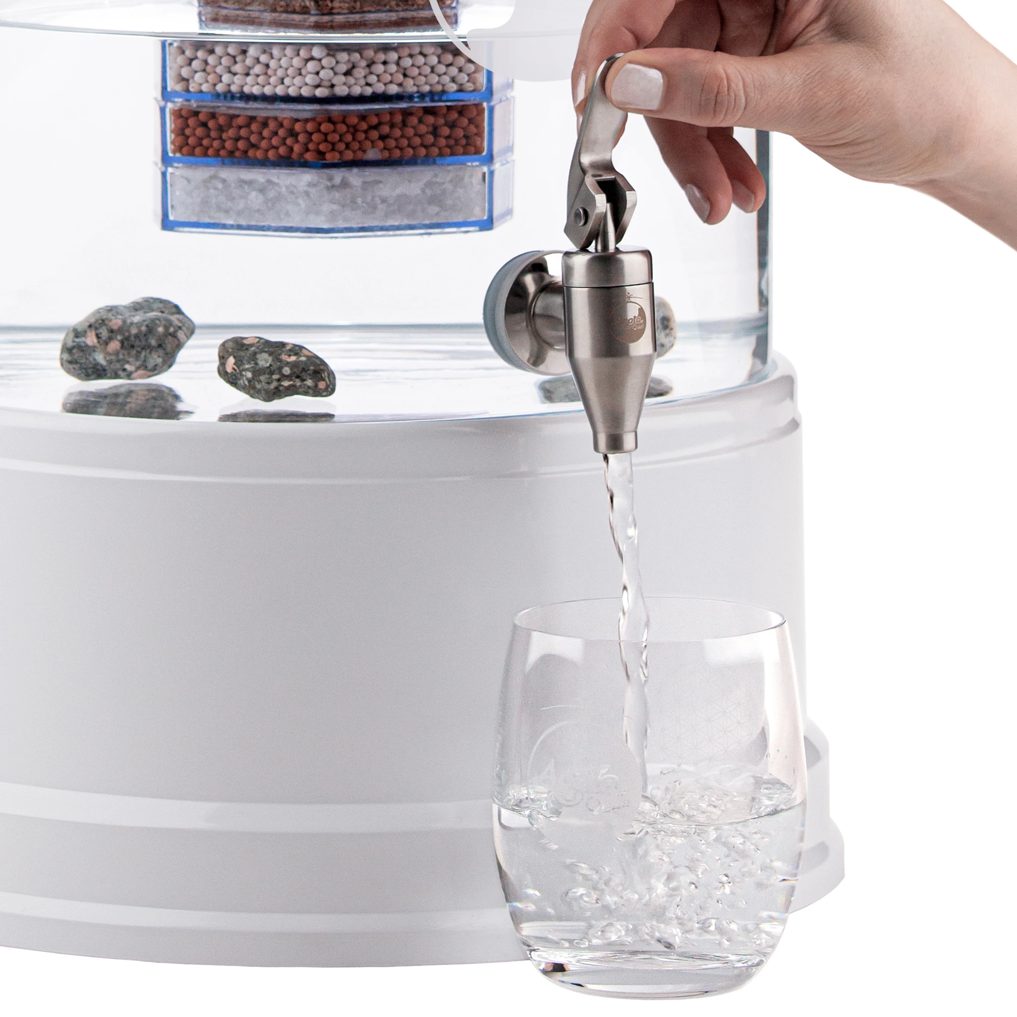 Zu sehen ist der Edelstahl Wasserhahn Yamashita für Standfilter an einem Glastank in kristallklar montiert. Der Hahn ist silber, eine Hand drückt den Hebel zum öffnen nach oben, Wasser läuft in ein darunter stehendes Glas.