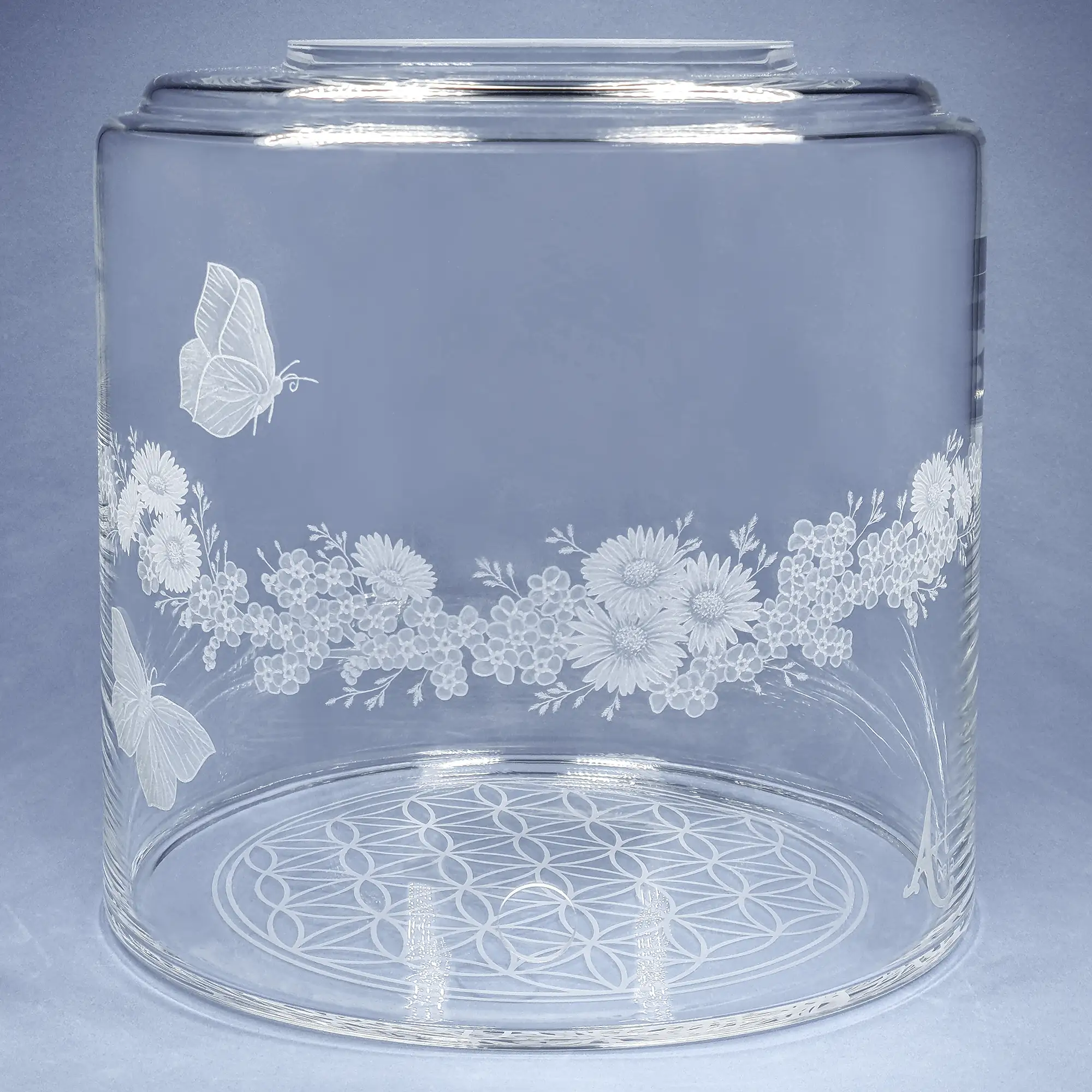 Vorratstank aus Glas für einen 8Liter Acala Wasserfilter in klarem Glas mit dem gravierten Kranz,umlaufende um das runde Glas.In dem Granz sind Vergissmeinnicht, Schmetterlinge und Gänseblümchen.Vorderansicht.